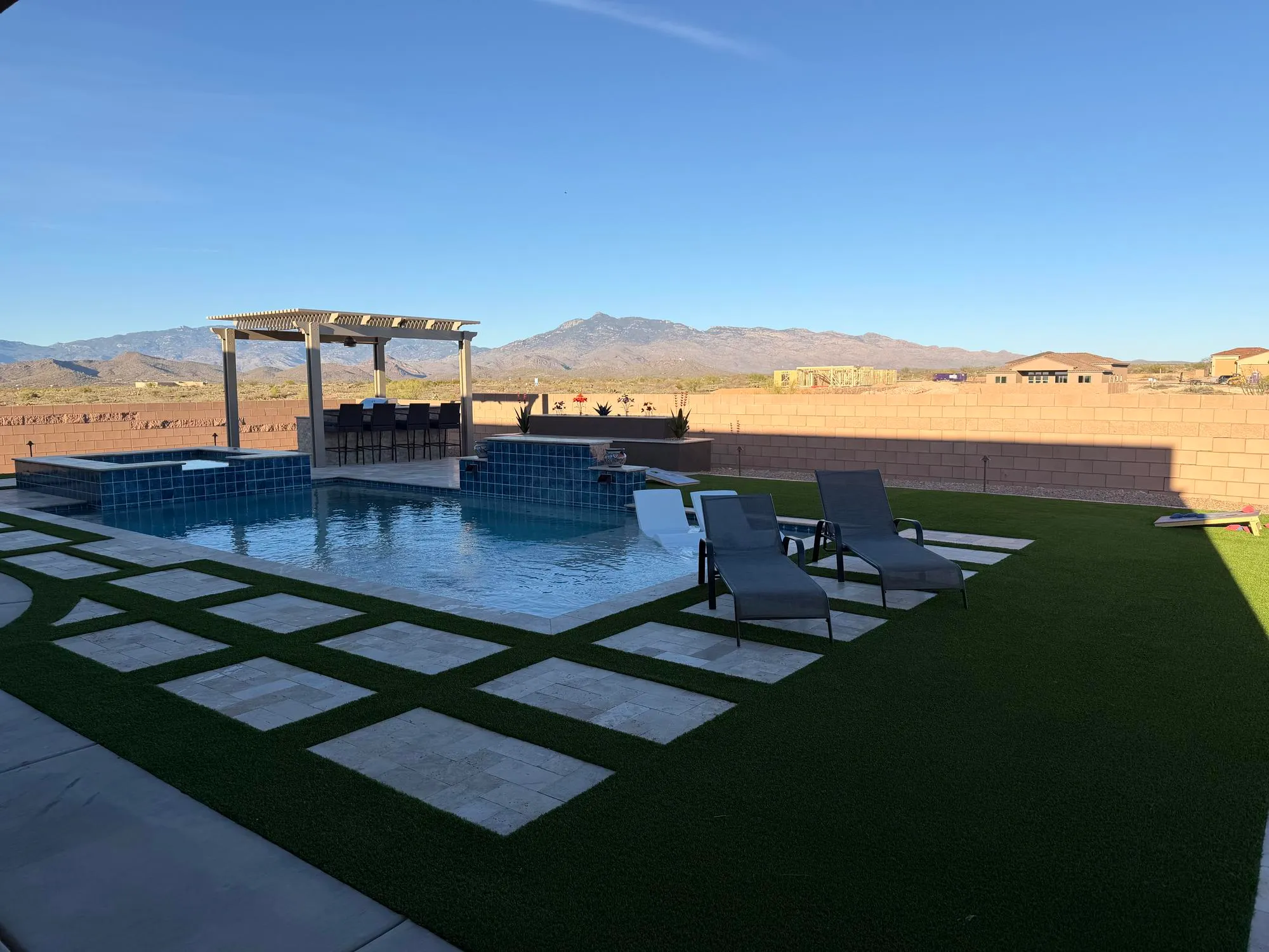 Backyard pool, pergola, and hardscape with mountain views by Sorce Signature Outdoors